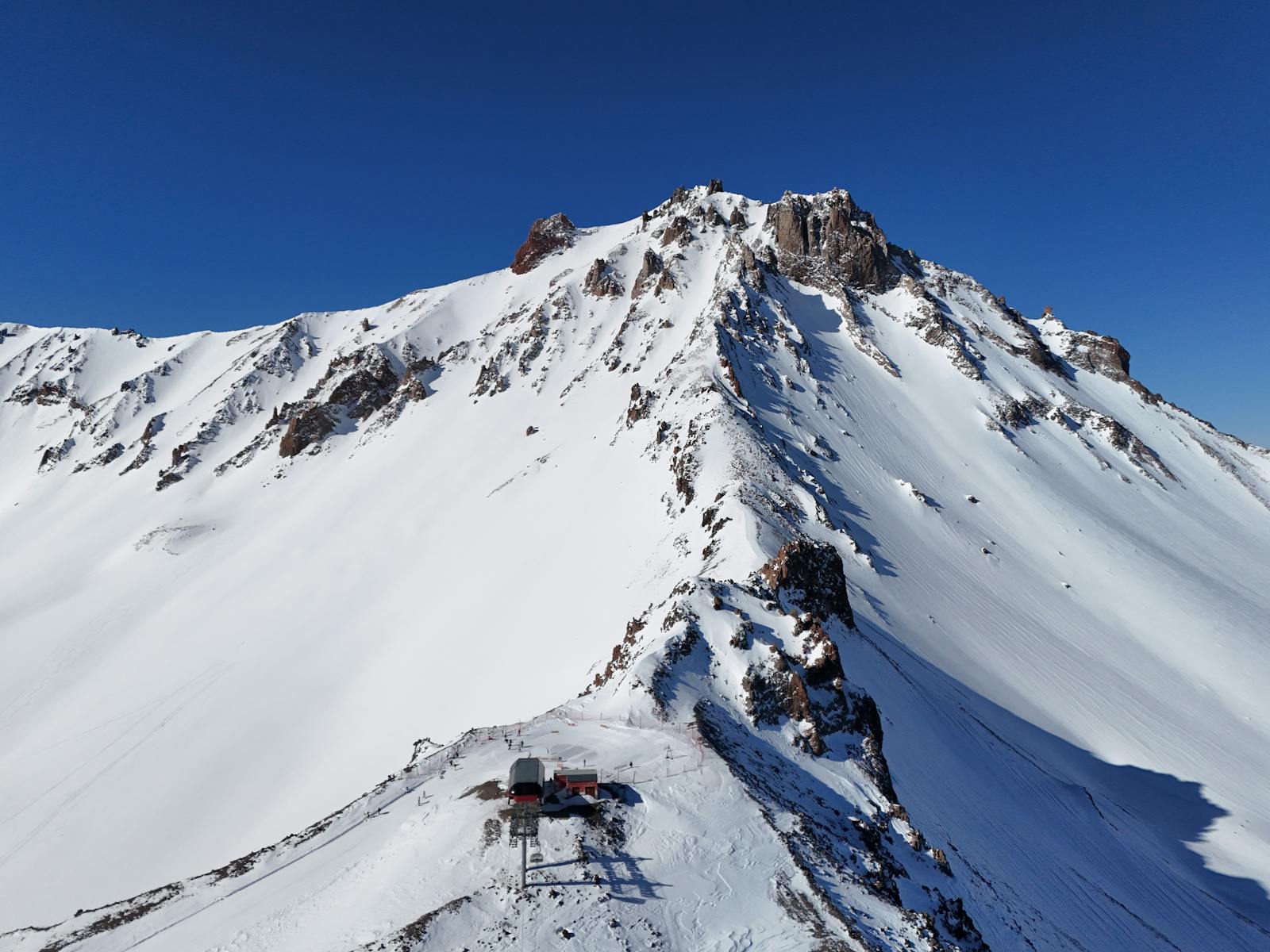 Stunning aerial shot of Mount Erciyes capped with snow under clear blue skies.